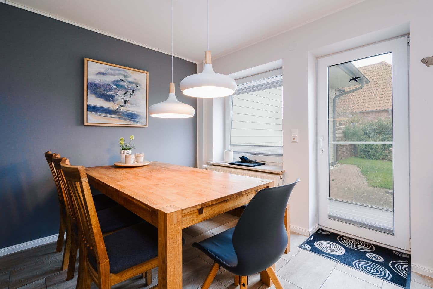 Moderne Küche mit Esstisch und Zugang zum Garten.